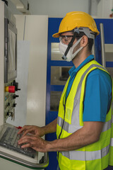 factory worker with face mask working at factory control panel
