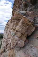 Layered sedimentary rock protruding from mountain vertical view