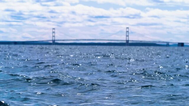 Waves of Makinac Straight in the foreground. a 4K focus pull toward Makinac Bridge in the distance. Everything flows with hues of blue in this painterly composition.