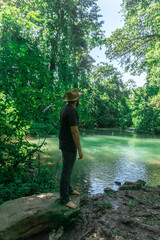 Man standing in front of a beautiful river with a green color water in Honduras