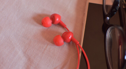 mobile phone, headphones, glasses on bed, hipster style.