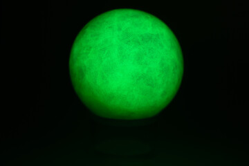 glowing green spheres fluorite on a black background looks like a planet or moon