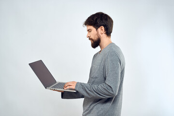 A man in a gray sweater with a laptop hands lifestyle technology communication internet work