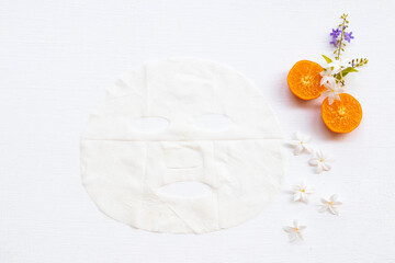 natural aroma sheet mask extract fruit orange health care for skin face essence face mask and flower arrangement flat lay style on background white
