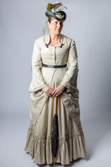 A middle-aged woman in a Victorian costume holding a parasol