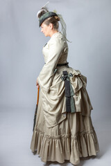 A middle-aged woman in a Victorian costume holding a parasol