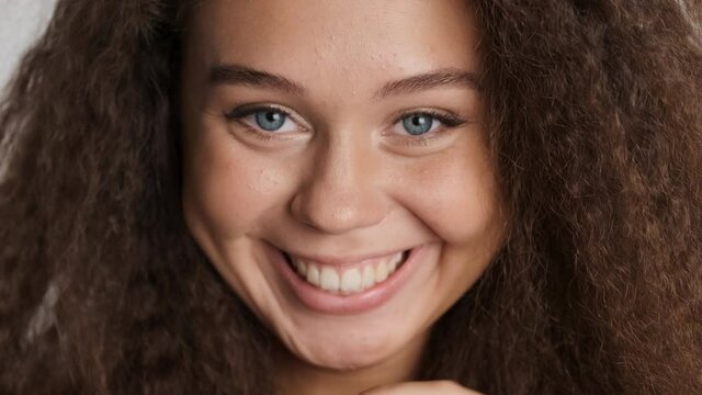 Close up attractive cheerful brunette girl happily smiling in camera isolated. Overjoyed expression