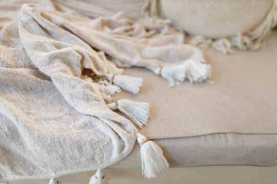  Bedding, morning light, bedroom style and design. Knitted white blanet on the sofa