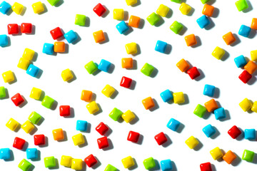 Candy.  Colorful candies are scattered randomly on a white background top view frame copy space. Chewing gum, and dragees are scattered.