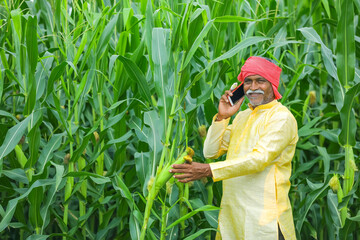 Indian farmer talking on mobile phone at Agriculture field