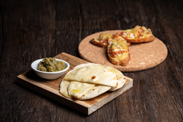 Bruschetta with half dried tomatoes and cheese. Middle Eastern meze with pita, olives, colorful hummus, babaganush, pickles, vegetables. Healthy food, vegan vegetable dish. tacos and snack wood table