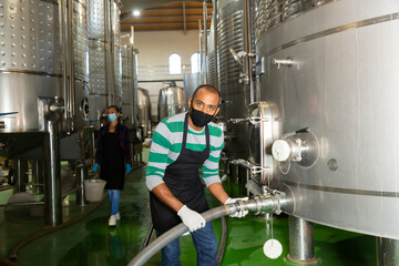 Wine producer controlling production wine in winery, preparing for wine filtration