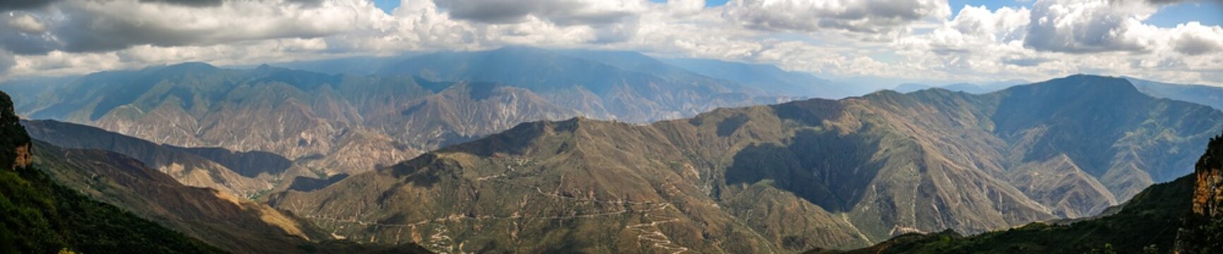 Impressive panorama of mountains  and Chicamocha canyon with white clouds from Monument of the Virgin Mary at Chicamocha National Park, Colombia