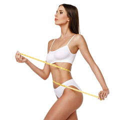Slim tanned woman's body over gray background - waist measurement