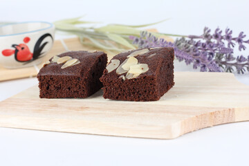 Two brownies on a cutting board.