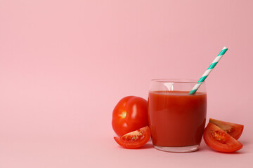 Glass with fresh tomato juice on pink background