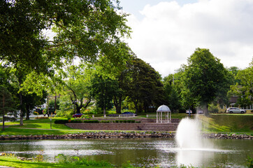 Picturesque city scape with historic New England style houses or cottages, flowers and parks in...