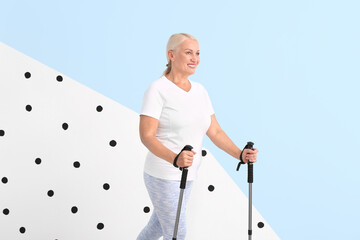 Mature woman with walking poles on color background