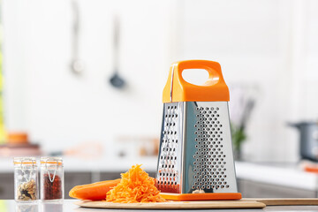 Metal grater and carrot on kitchen table