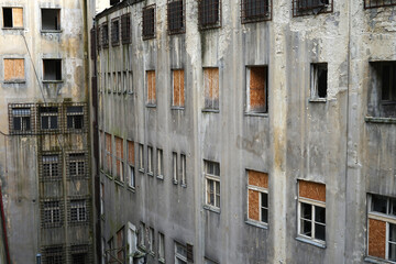 Old abandoned communist prison with broken windows and rusty secured grills, scary landmark