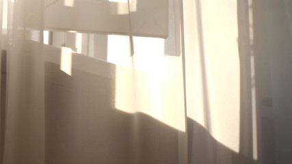 wind blows through the open window in the room. Waving white tulle near the window. Morning sun lighting the room, shadow background overlays.