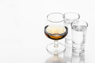 Brandy glass isolated. Cognac alcohol background. Golden liquor closeup. Two vodka shots empty copy space.