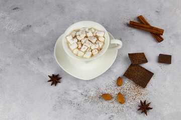 A ceramic cup with hot cocoa or chocolate with marshmallow on light background.