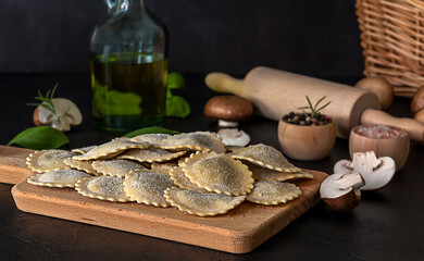 Fresh raw italian filled pasta ravioli or tortelli with mushrooms, pesto, and ricotta. Homemade cuisine, vegetarian recipe.