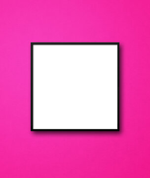 Black square picture frame hanging on a pink wall