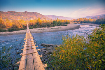 Hanging rope wooden bridge over mountain river