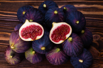 Tasty figs in a bowl on wooden background. Top view.
