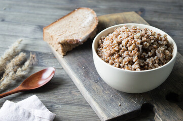 Buckwheat porridge with homemade bread on the wooden background