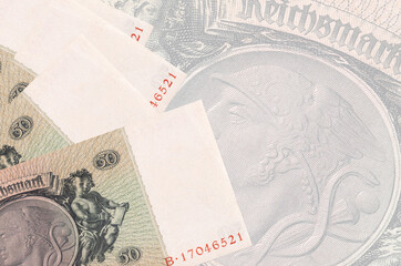 50 Reich marks bills lies in stack on background of big semi-transparent banknote. Abstract...