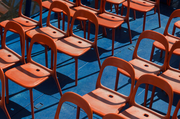Orange chairs placed for passengers on the blue deck of a river boat