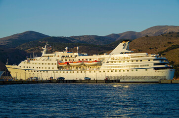 Classic cruiseship or cruise ship liner with motor yacht in port of Kefalonia in Greece during...