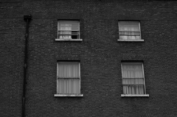 Black and white old building in the city with four windows