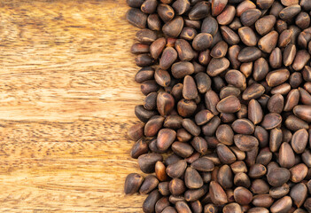 Pine nuts over wooden background.