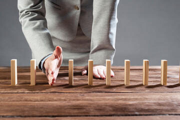 Business woman interrupting domino effect