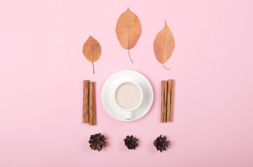 Autumn background with coffee, cinnamon and leaves on pink background