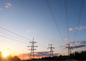 High-voltage power lines at sunset or sunrise. High voltage electric transmission tower