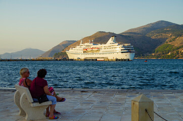 Classic cruiseship or cruise ship liner with motor yacht in port of Kefalonia in Greece during...