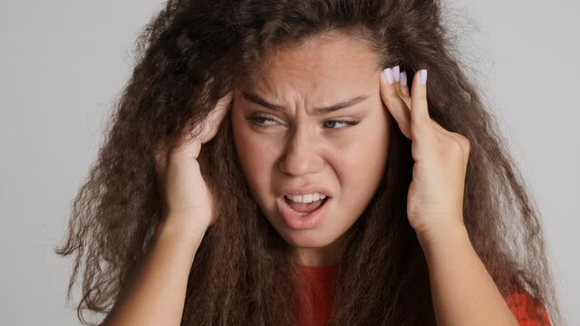 Distressed tired brunette girl massage temples feeling headache isolated on white background
