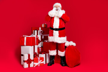 Full length body size view of handsome fat overweight Santa saying information bargain pile stack giftboxes delivering delivery North Pole isolated bright vivid shine vibrant red color background