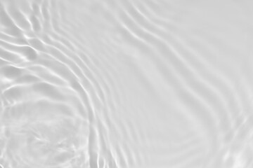 Fototapeta na wymiar de-focused. Blurred desaturated transparent clear calm water surface texture with splashes and bubbles. Trendy abstract nature background. White-grey water waves in sunlight. Copy space.