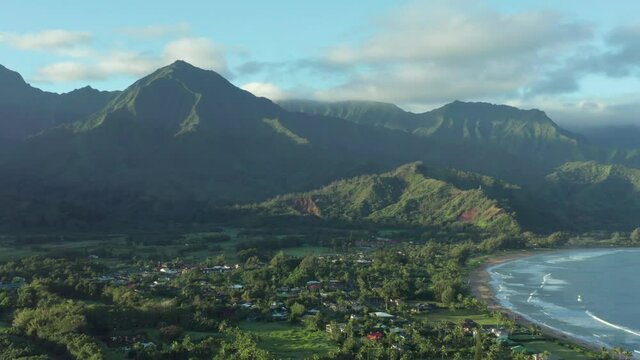 Kauai Hanalei Bay 4k aerial drone shot. View of town village by the ocean between palm trees. Vacation dream in tropical environment. Overview on beautiful sunny morning in Hawaii