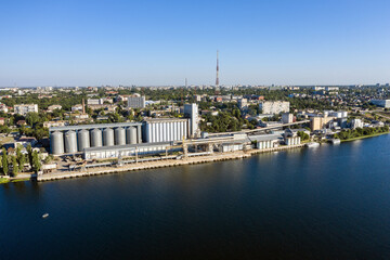 Obraz premium Grain elevator and silos near the river aerial view.
