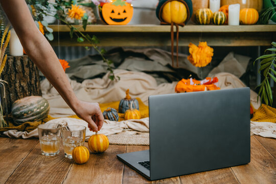 Halloween festivities in new normal, New Trick or Treating Regulations celebrate Halloween safely during COVID 19 pandemic. Open laptop ready for online meeting, pumpkins and festive decor