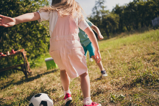 Photo of family two little children siblings play football kick ball have fun wait parents make breakfast table relax sunny day house green grass lawn park backyard outside outdoors