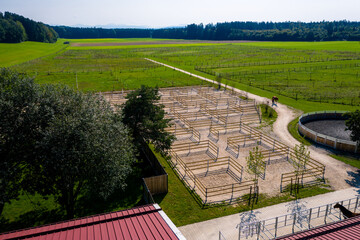 Outdoor boxes paddocks for horses on a farm. Wood fences. Aerial Drone Photo