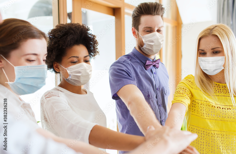 Canvas Prints business, pandemic and health concept - creative team wearing face protective medical masks for protection from virus disease stacking hands at office